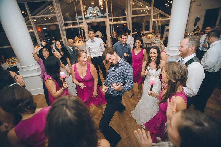 Guest plays the air guitar during a reception at Oceanblue/Westhampton Bath & Tennis in Westhampton, NY. Captured by NYC wedding photographer Ben Lau.