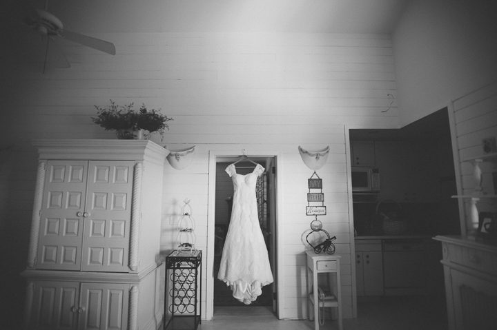 Wedding dress hangs in teh doorway of the bridal suite  at Oceanbleu in Westhampton, NY. Captured by NYC wedding photographer Ben Lau.