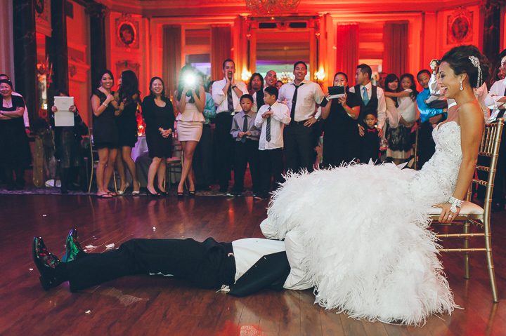 Garter toss during a wedding reception at the Belvedere Hotel. Captured by NYC wedding photographer Ben Lau.