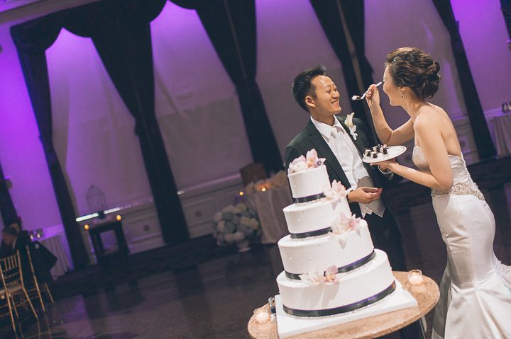Cake cutting during a wedding reception at The Estate at Florentine Gardens in River Vale, NJ. Captured by Northern NJ wedding photographer Ben Lau.