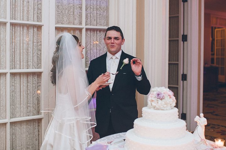 Bride feeds groom some cake during a wedding reception at Glen Cove Mansion. Captured by NYC wedding photographer Ben Lau.