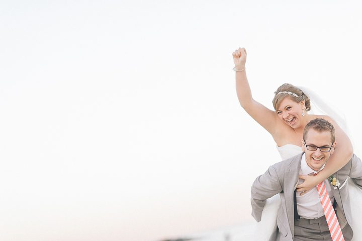 Bride jumps on the groom's back at their wedding at McLoone's Pier House in Long Branch, NJ. Captured by NYC wedding photographer Ben Lau.