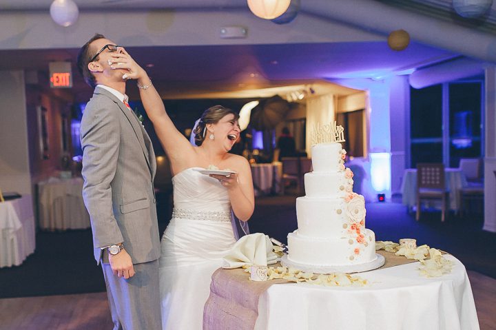 Bride smushes cake into the groom's face at their wedding at McLoone's Pier House in Long Branch, NJ. Captured by NYC wedding photographer Ben Lau.