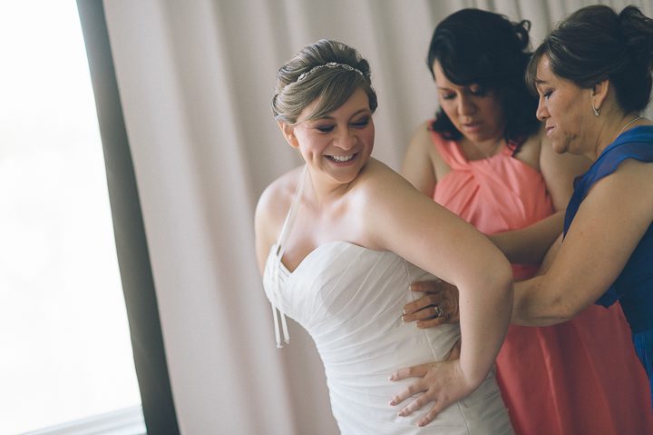 Bride gets into her dress at the Bungalow Hotel for a McLoone's Pier House Wedding in Long Branch, NJ. Captured by NYC wedding photographer Ben Lau.