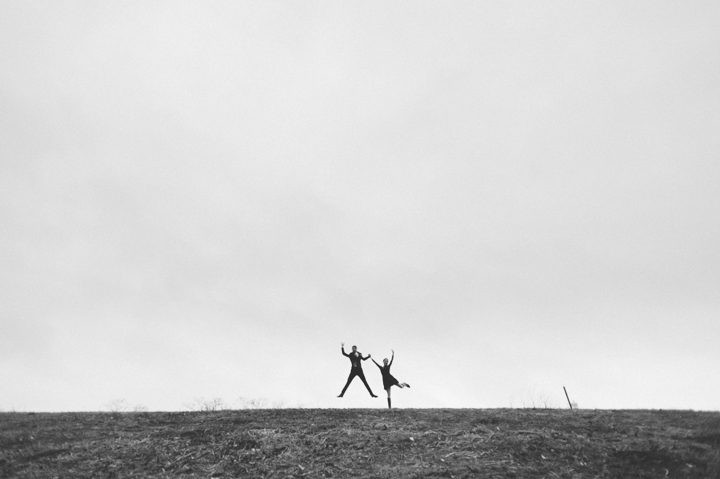 Zoie and Daniel jump in the air during their rainy day engagement session with New York City wedding photographer Ben Lau.
