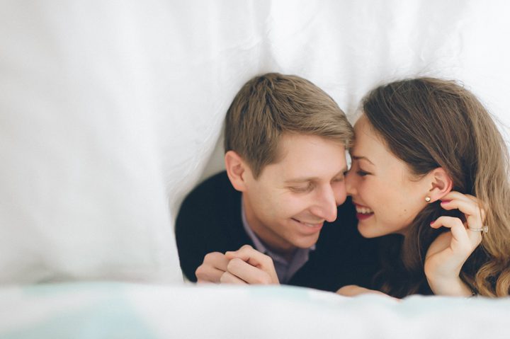 Zoie and Daniel play under the sheets during their rainy day engagement session with New York City wedding photographer Ben Lau.