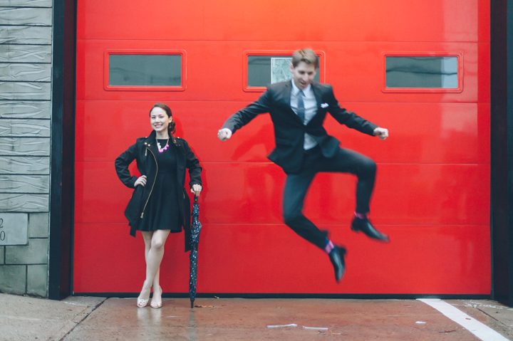 Daniel jumps in the air during their rainy day engagement session in Ridgefield Park with New York City wedding photographer Ben Lau.