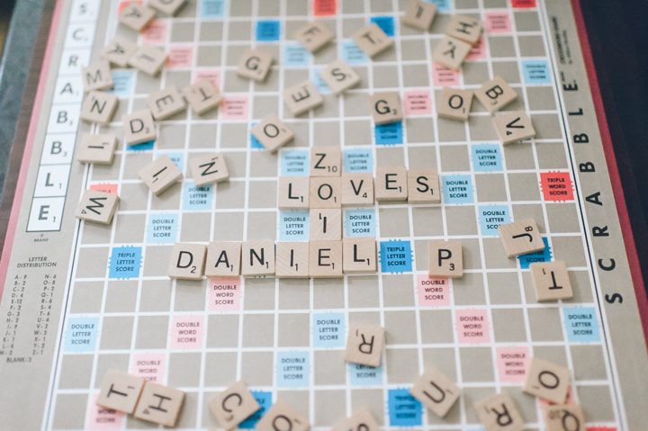 Zoie and Daniel play scrabble during their rainy day engagement session with New York City wedding photographer Ben Lau.