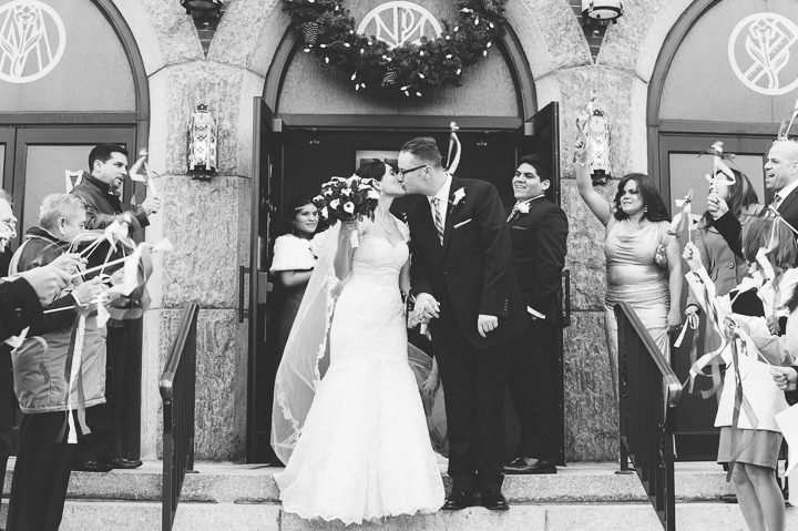 Bride and groom kiss in front of church. Captured by NYC wedding photographer Ben Lau.