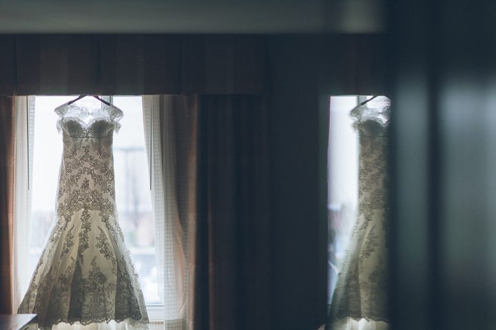 Wedding dress hanging on the window. Crest Hollow Country Club wedding captured by NYC wedding photographer Ben Lau.