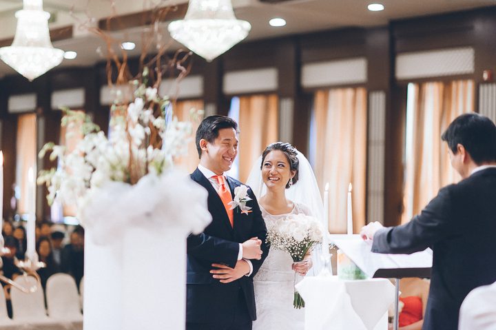 Bride smiles at the groom during a wedding ceremony at Dae Dong Manor in Flushing, NY. Captured by NYC wedding photographer Ben Lau.