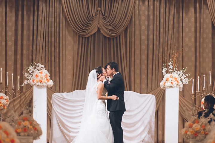 Bride and groom kiss during their wedding ceremony at Dae Dong Manor in Flushing, NY. Captured by NYC wedding photographer Ben Lau.