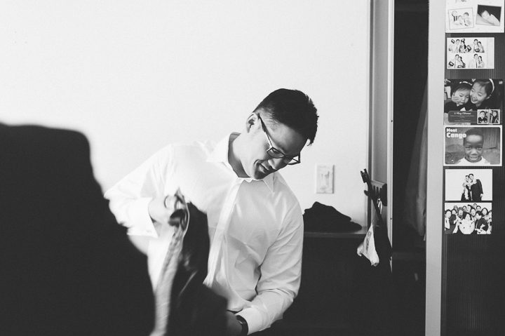 Groomsman gets ready on the morning of a wedding at the Sheraton Laguardia East in Flushing, NY. Captured by NYC wedding photographer Ben Lau.