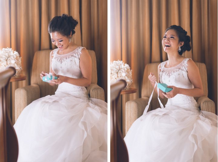 Bride opens her gift on the morning of her wedding at Sheraton Laguardia East in Flushing, NY. Captured by NYC wedding photographer Ben Lau.