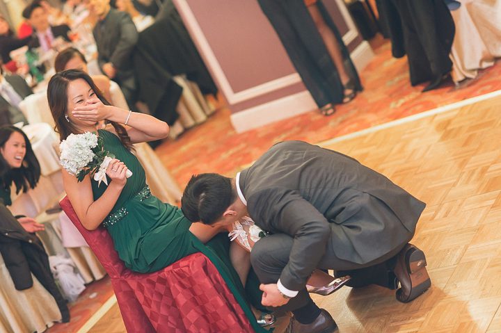 Garter toss during a wedding reception at Mudan's. Captured by NYC wedding photographer Ben Lau.