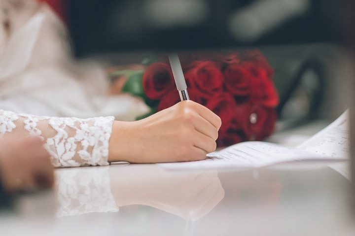 Couple signs their papers at the NYC Marriage Bureau. Captured by NYC City Hall Wedding Photographer Ben Lau.
