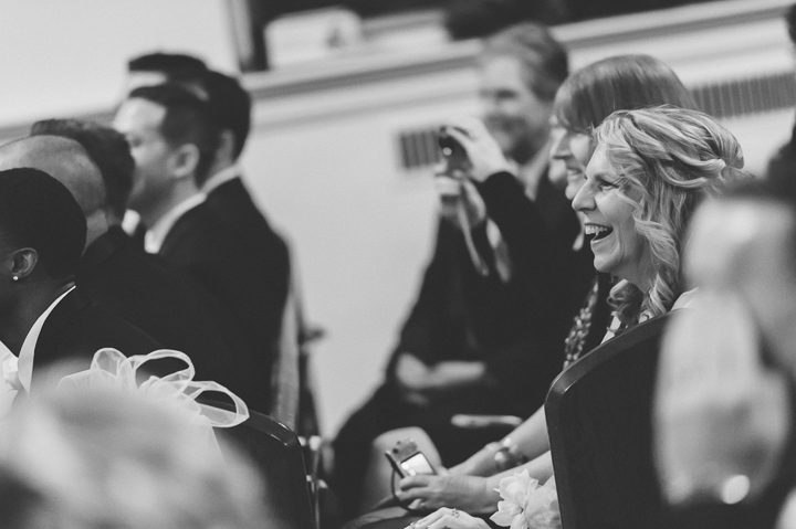Mother of the groom laughs during a wedding ceremony at St. Mary's Church in Pompton Lakes, NJ. Captured by Northern NJ wedding photographer Ben Lau.