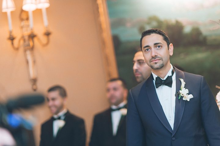 Groom watches his bride come down the aisle during their wedding ceremony at the Essex House in NYC. Captured by NYC wedding photographer Ben Lau.