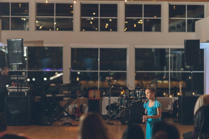Flower girl toasts during a wedding reception at the Maritime Parc in Jersey City, NJ. Captured by NYC wedding photographer Ben Lau.