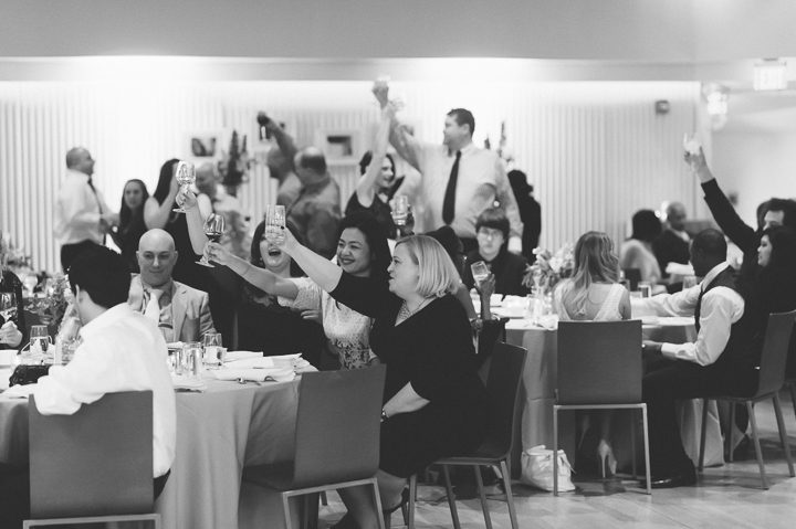 Guests toast during a wedding reception at the Maritime Parc in Jersey City, NJ. Captured by NYC wedding photographer Ben Lau.