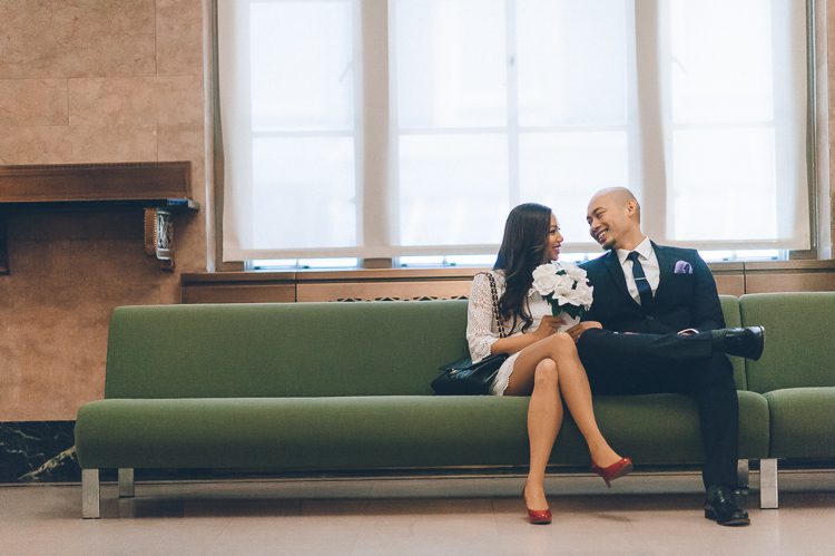 Jen and Edwin wait on the couch at the marriage bureau in NYC. Captured by NYC City Hall wedding photographer Ben Lau.