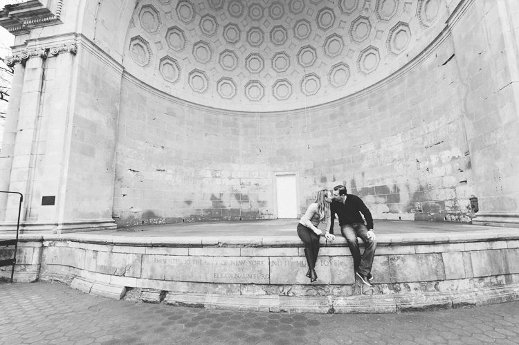 Couple sits together on an empty stage, during their engagement session in Central Park, with NYC wedding photographer Ben Lau.