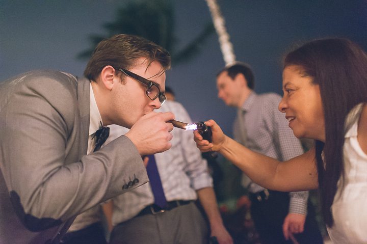 Guest light a cigar during a wedding reception at the Red Fish Grill in Miami, FL. Captured by Miami wedding photographer Ben Lau.