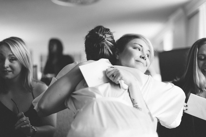 Bridesmaid hugs the bride before the wedding at the Franklin Institute in Philadelphia. Captured by NYC wedding photographer Ben Lau.