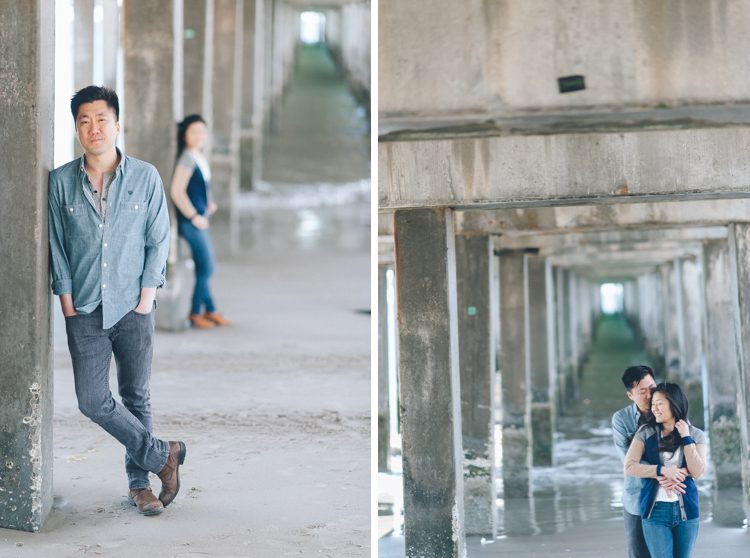 Couple poses under the boardwalk during their engagement session in Coney Island. Captured by NYC wedding photographer Ben Lau.