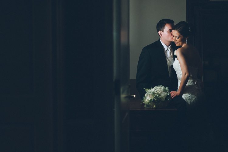 Groom kisses bride in the shadows during their wedding photo session at The Palace at Somerset Park. Captured by awesome NJ wedding photographer Ben Lau.