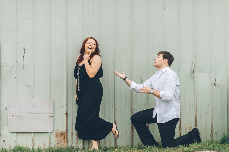 Yuriy serenades Alina with flowers during their engagement session in Baltimore with NJ wedding photographer Ben Lau.