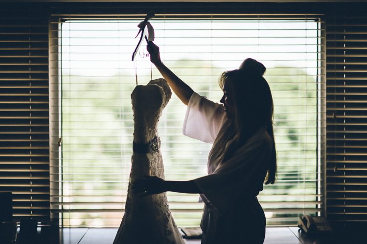 Bride inspects her dress on the morning of her wedding in Morristown, NJ. Captured by NJ wedding photographer Ben Lau.