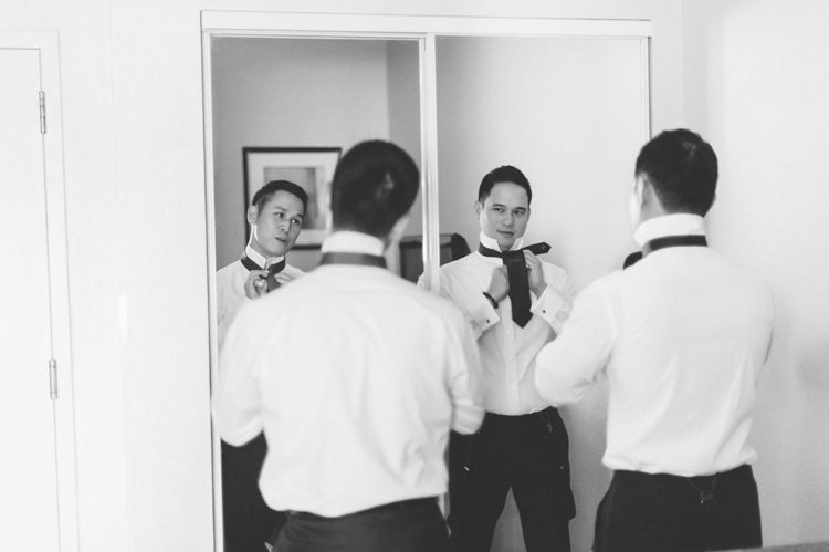 Groom preps in hotel room in Jersey City. Captured by NYC wedding photographer Ben Lau.