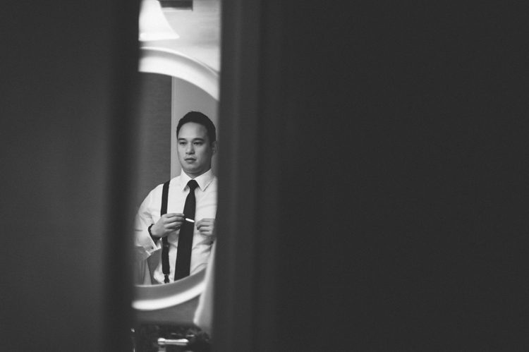 Groom preps in hotel room in Jersey City. Captured by NYC wedding photographer Ben Lau.