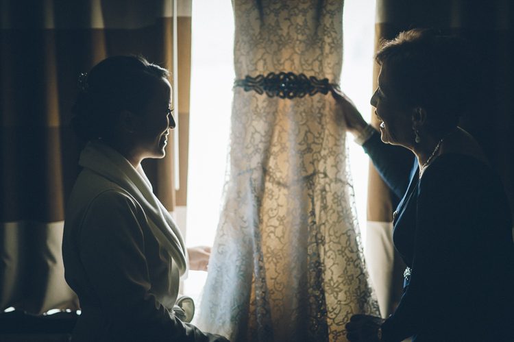 Bride and her mother admire her wedding dress in their hotel room in Jersey City. Captured by NYC wedding photographer Ben Lau.