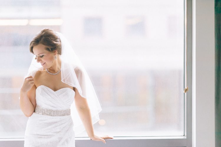 Bride smiles during her portraits at the Conrad hotel in NYC. Captured by NYC wedding photographer Ben Lau.