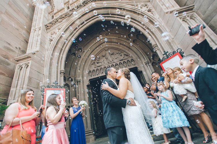 Bride and groom kiss at the end of their wedding ceremony at the Trinity Church in NYC. Captured by NYC wedding photographer Ben Lau.