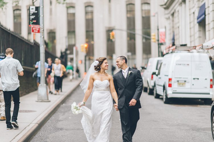 Bride and groom hold hands in the streets of NYC. Captured by NYC wedding photographer Ben Lau.
