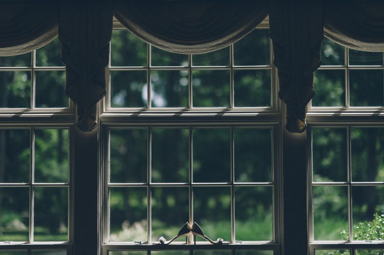 Wedding shoes on a window on the morning of a wedding at the Florence Griswold Museum in Old Lyme, CT. Captured by NYC wedding photographer Ben Lau Photography.