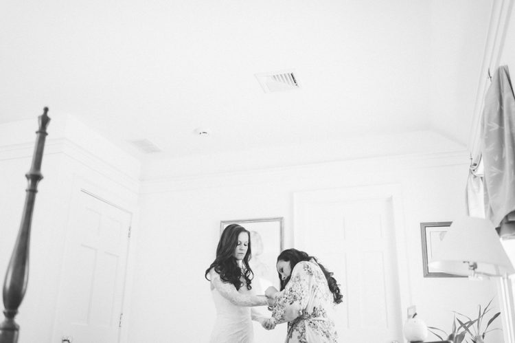 Bride puts on her wedding dress on the morning of her Florence Griswold Museum Wedding in Old Lyme, CT. Captured by NYC wedding photographer Ben Lau Photography.