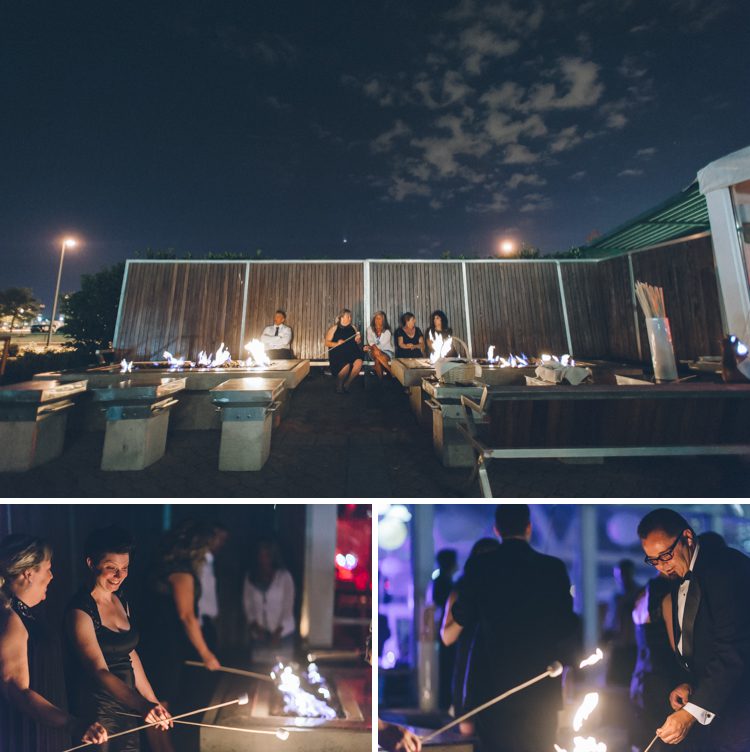 Guests make smores over a fire pit during a wedding reception at the LIberty House in Jersey City, NJ. Captured by awesome NJ wedding photographer Ben Lau.
