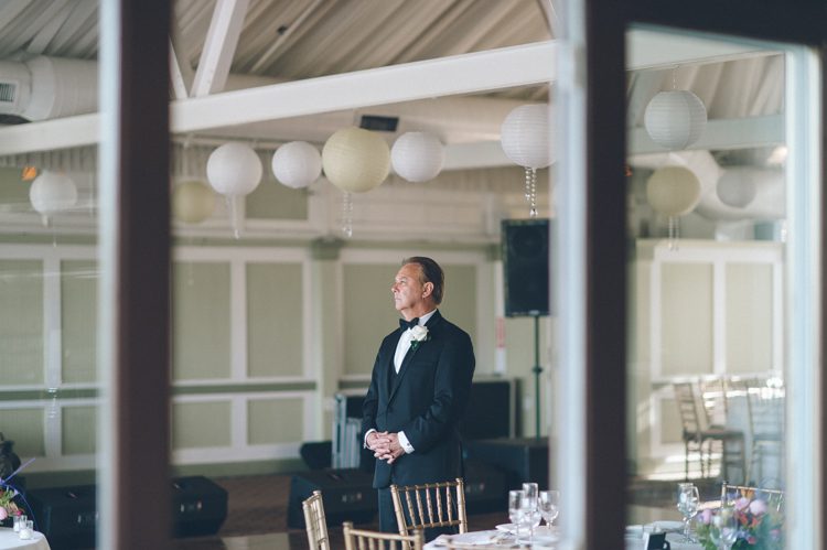 Father of the bride thinking quietly to himself, while waiting inside the Liberty House in Jersey City, NJ. Captured by awesome NJ wedding photographer Ben Lau.