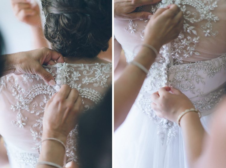 Bride gets into her dress on the morning of her wedding at the Inn at New Hyde Park. Captured by NYC wedding photographer Ben Lau.