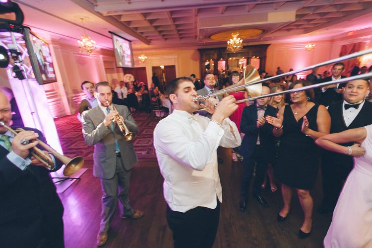 Groom plays the trombone for his bride during his wedding at the Inn at New Hyde Park. Captured by NYC wedding photographer Ben Lau.