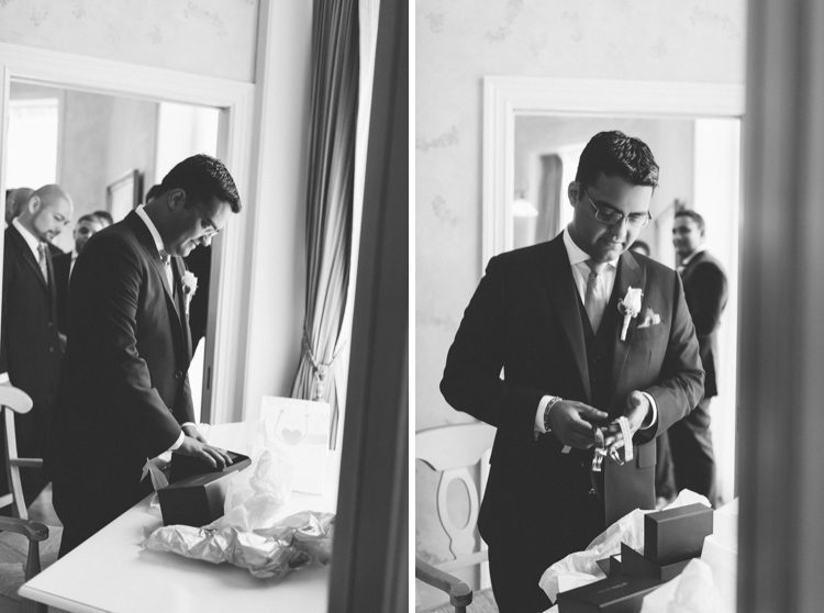 Groom opens his gift on the morning of his Oheka Castle wedding in Long Island, NY. Captured by NYC wedding photographer Ben Lau.