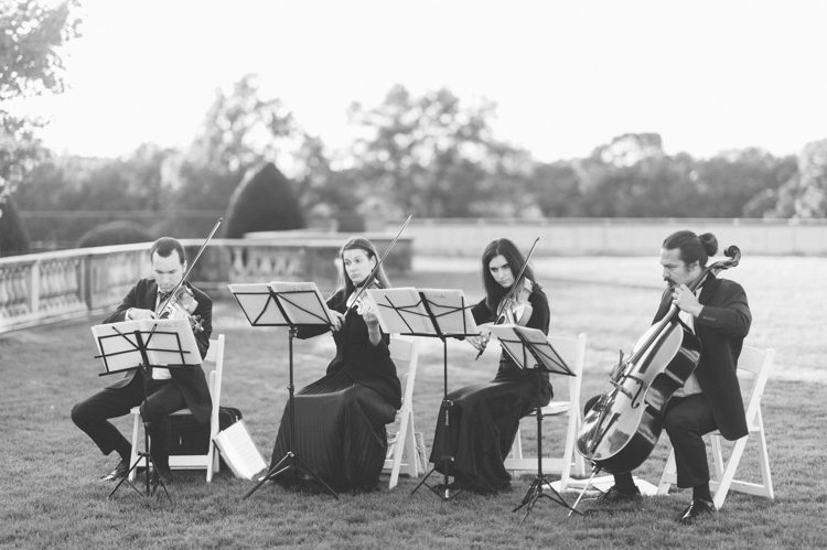 String quartet playing during a wedding ceremony at Oheka Castle in Long Island, NY. Captured by NYC wedding photographer Ben Lau.