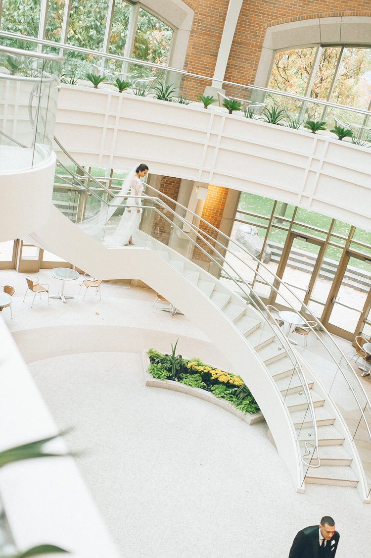 Bride descends the stairs during her first look on the morning of her Seaport Hotel wedding in Boston, MA. Captured by NYC wedding photographer Ben Lau.