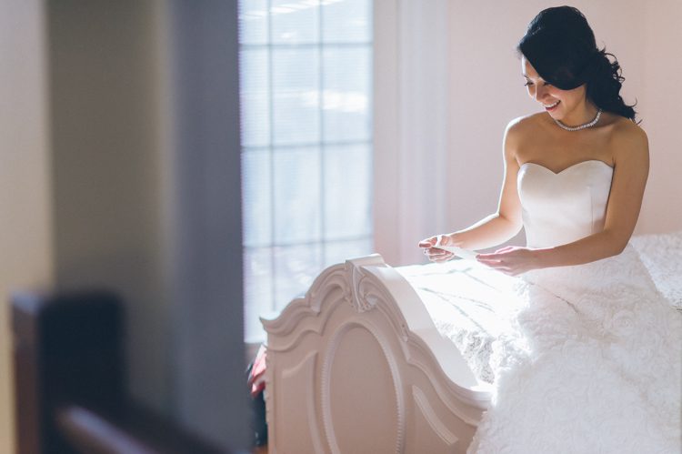 Bride reads a letter from her groom on the morning of her wedding at the Venetian in Garfield, NJ. Captured by NJ wedding photographer Ben Lau.