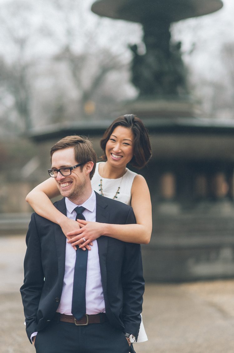 Bride and groom pose for portraits at the Bethesda Fountain during their engagement session in Central Park. Captured by NYC wedding photographer Ben Lau.