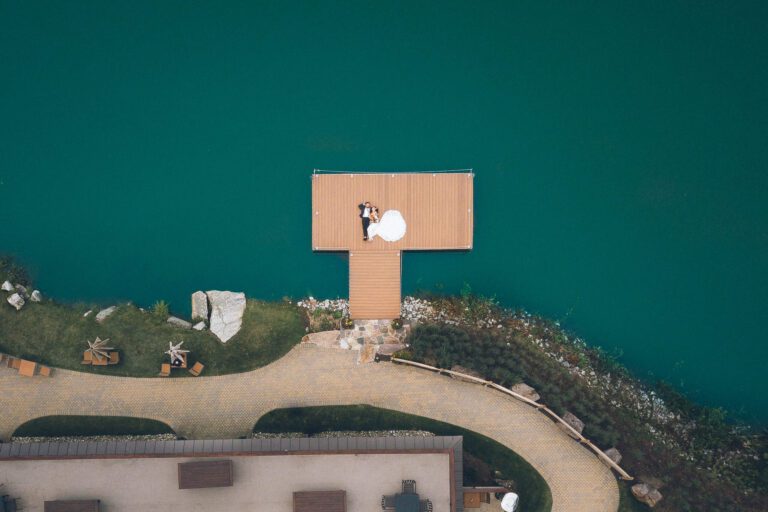 Aerial Rock Island Lake Club wedding photo taken by a drone, of a couple laying down on the docks. Captured by NJ wedding photographer Ben Lau.